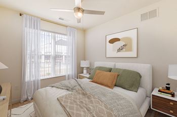 A bedroom with a bed, nightstands, and a ceiling fan.